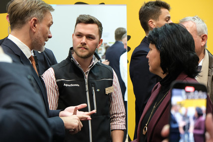 Christian Lindner, Carina Konrad reden mit einem jungen Mann von Agrarscouts. 