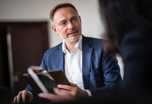 Christian Lindner am Schreibtisch im Gespräch mit einer Frau. 